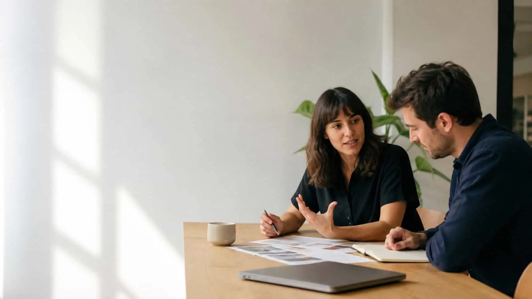 Two marketing professionals reviewing a client plan together at a table